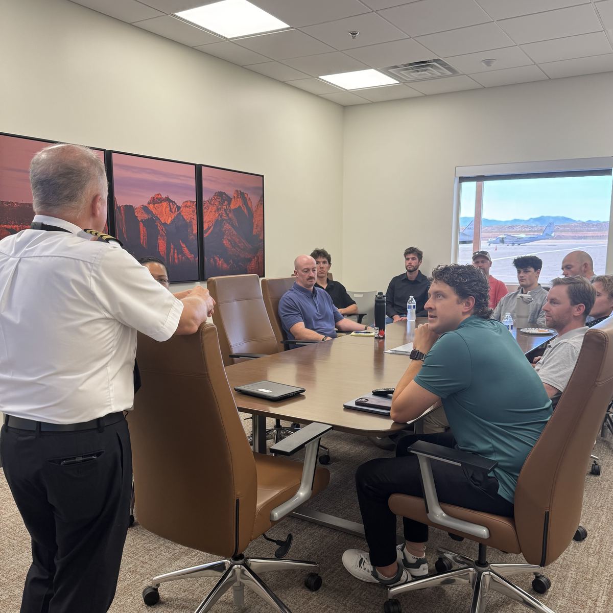 An airline captain leading a ground school session with Axiom students