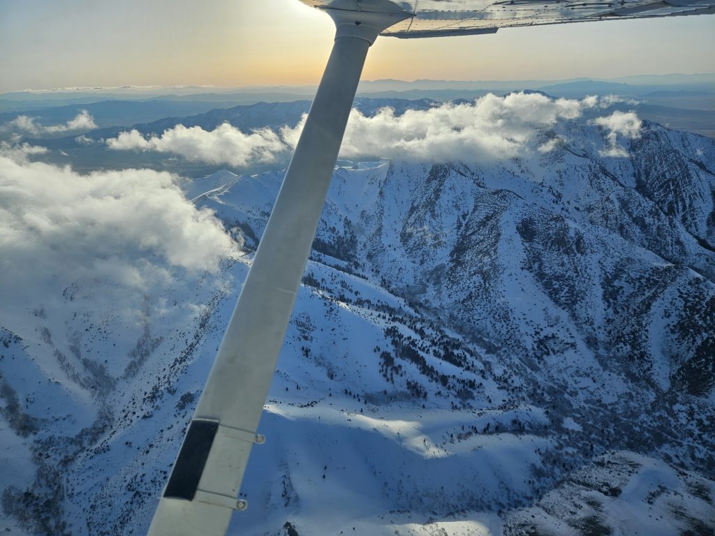 Aerial view of snow-covered Utah mountains from an Axiom Aviation training aircraft – Best Pilot Logbook App Options for 2026