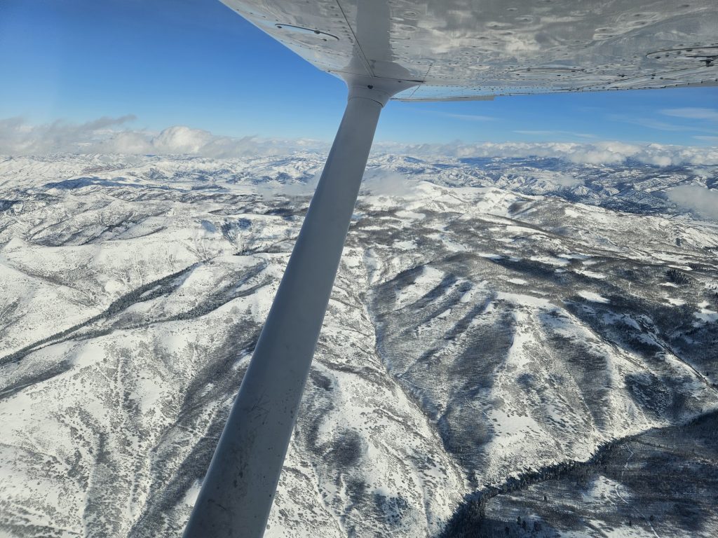 Aerial view of snow-covered Utah mountains from an Axiom Aviation training aircraft – Best Aviation Headset Reviews for Pilots
