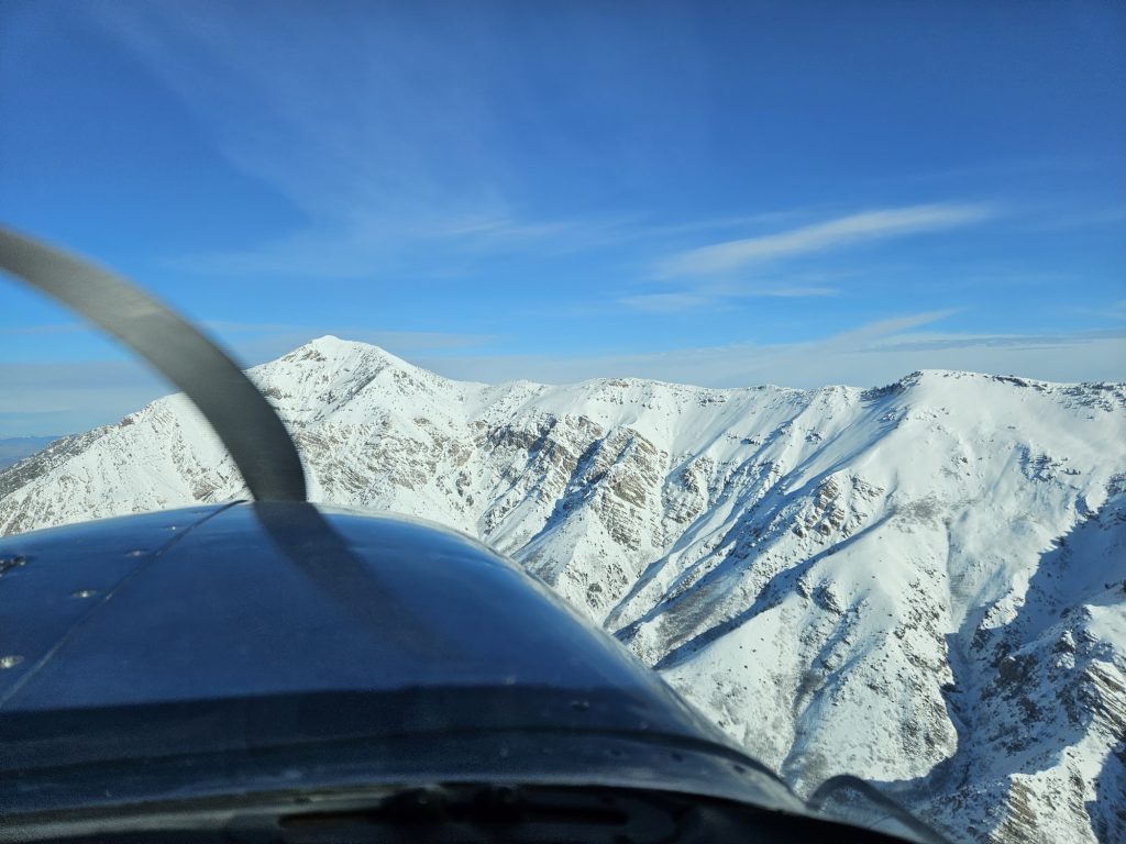 Aerial view of snow-covered Utah mountains from an Axiom Aviation training aircraft – How to Build Flight Hours