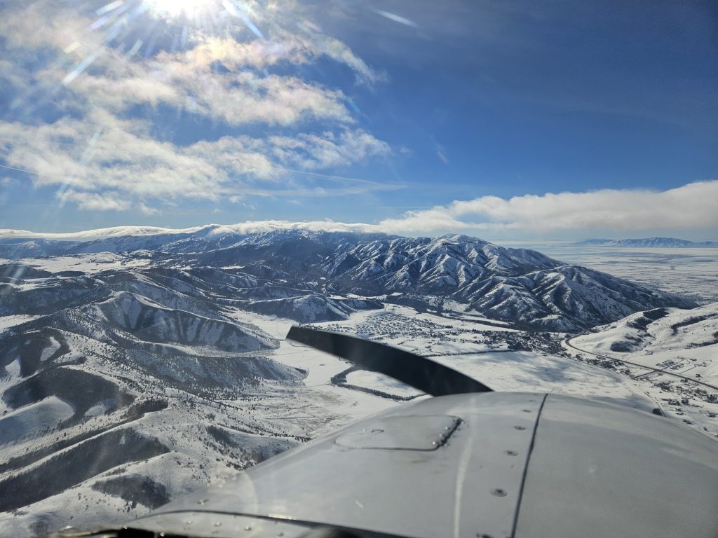 Aerial view of snow-covered Utah mountains from an Axiom Aviation training aircraft – Best Pilot Logbook App Options for 2026