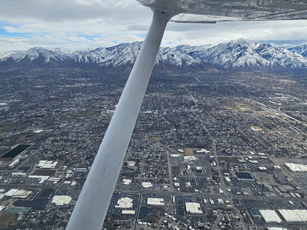Aerial view of the valley below from an Axiom Aviation Cessna – Best Pilot Logbook App Options for 2026