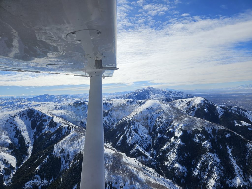 Aerial view of snow-covered Utah mountains from an Axiom Aviation training aircraft – Best Aviation Headset Reviews for Pilots